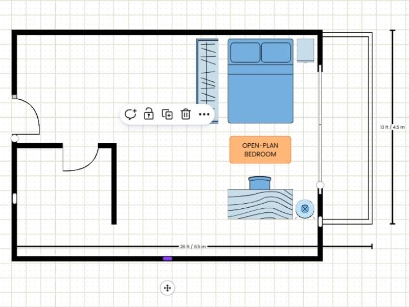 2D floor plan made with a template in Canva. It shows how to edit in the template. One long wall is dragged down to extend the room. The floor plan shows a two-room floor plan with a balcony and blue furniture such as a double bed, a closet, a nightstand, a desk with a chair and a lamp. There is also an orange label saying "open-plan bedroom". There are measurements showing the size of the floor plan outside the walls of the floor plan.