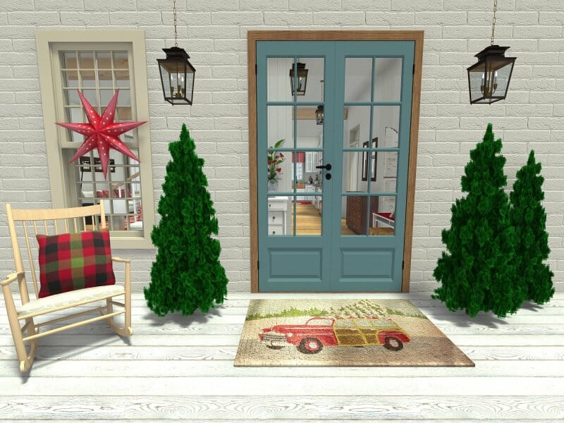 3D-rendered image of a festive front porch decorated for the holidays. The entrance features double blue French doors flanked by two green Christmas trees and hanging lantern lights. A doormat with a red vintage truck and tree design adds seasonal charm. To the left, a wooden rocking chair with a red and green plaid pillow sits next to a window decorated with a large red star ornament.