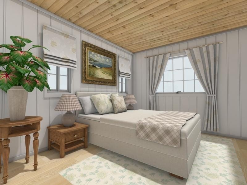 3D-rendered bedroom with a light and cozy cottage style. The room features a soft gray upholstered bed with patterned pillows and a plaid throw blanket. Wooden nightstands with table lamps flank the bed. A framed landscape painting hangs above the bed between two small windows with Roman shades. The room has light wood flooring, a pale floral area rug, and white paneled walls. A wood-paneled ceiling and striped curtains on the large window add warmth and charm. A wooden side table with a potted plant stands in the corner.