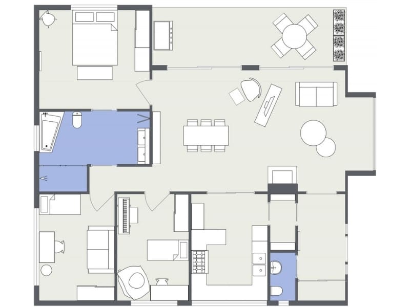 2D floor plan of a residential layout showing a bedroom, open-plan living and dining area with furniture, kitchen, multiple smaller rooms, and bathrooms highlighted in blue to distinguish wet areas.